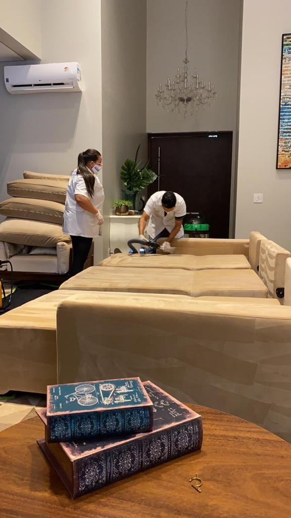 Equipe Super Clean Dourados — técnico e técnica realizando higienização profissional de estofados