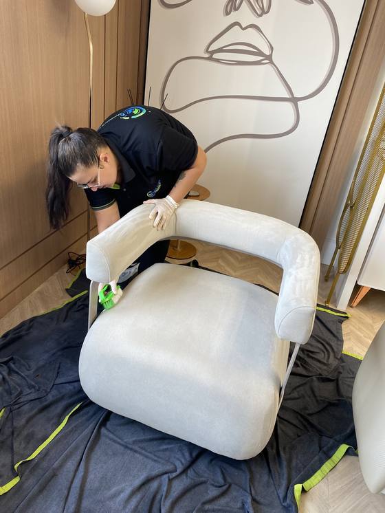 Técnica Super Clean higienizando poltrona branca em residência de alto padrão em Dourados-MS